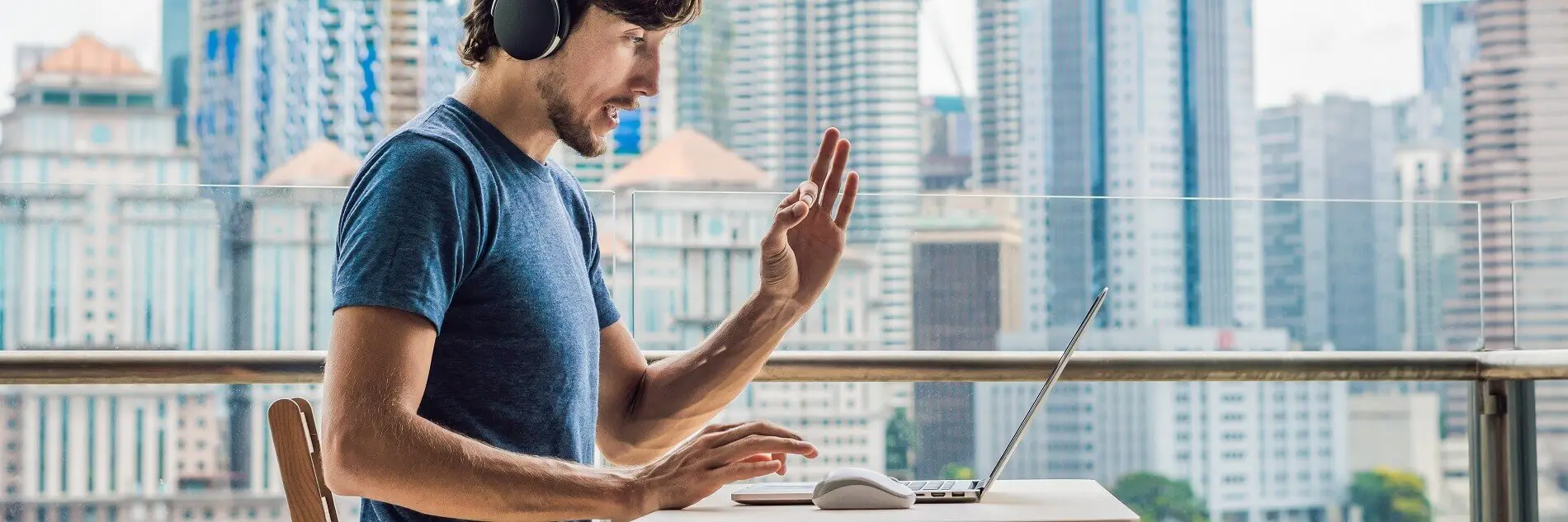 Mann mit Kopfhörern sitz am Laptop